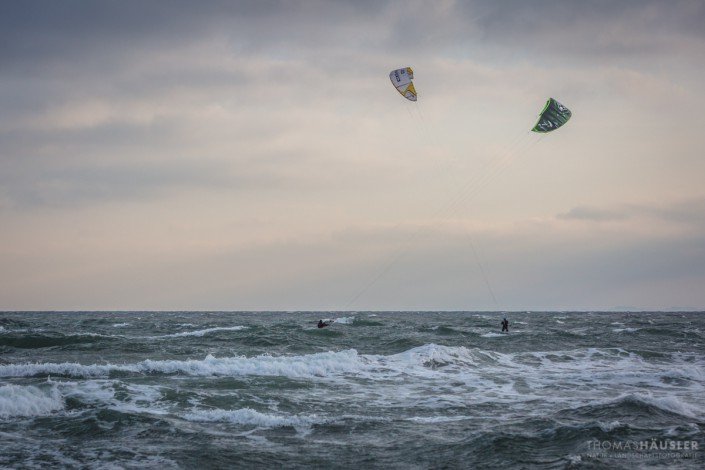 deutschland - Zwei Kite-Surfer auf der Ostsee, deren Drachen sich kreuzen.