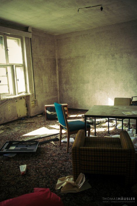 Lost Places - Blick in ein altes Zimmer mit Stuhl, Fernseher, Sessel