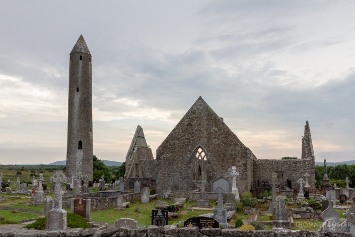 Irland - Kilmacduagh Monastery (irisch Cill Mhic Dhuach) ist eine Klosterruine im Ort Kilmacduagh, 5 km westlich der Ortschaft Gort im County Galway in Irland.
